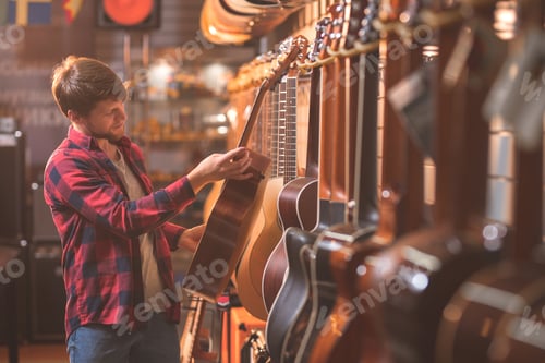 Preview: A young man choosing a guitar