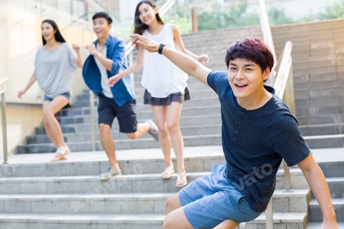 Preview: Young Chinese man sliding down banister on steps