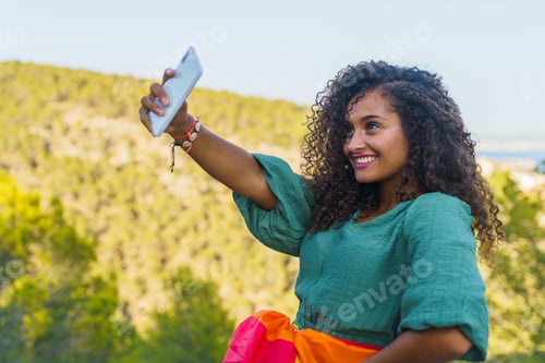 Preview: Smiling Woman Taking Selfie Outdoors on Sunny Day