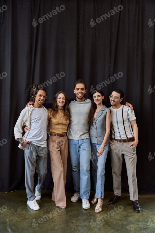 Preview: group photo of joyful multiethnic team near black drape in modern office, teamwork concept