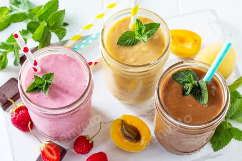 Preview: Strawberry, chocolate and apricot milkshake or smoothies on a white wooden background.