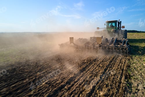 Preview: Aerial view of tractor plowing agriculural farm field preparing soil for seeding in summer