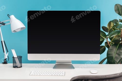 Preview: workplace with computer, lamp, stationery on white table near green plant on blue background