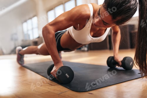 Preview: Gym woman doing pushups on dumbbells