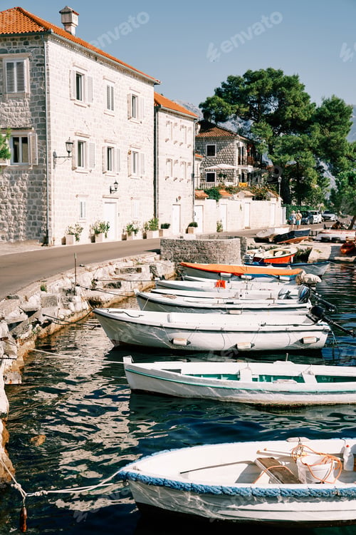 Preview: Fishing boats are moored in a row along the Perast waterfront lined with old stone houses