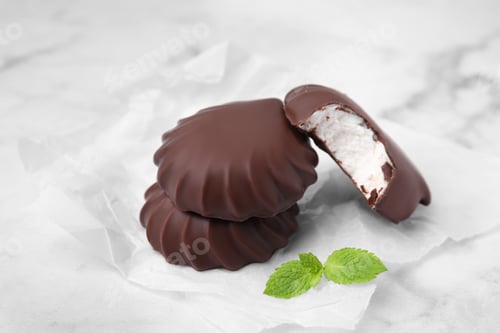Preview: Delicious chocolate covered marshmallows with mint on white marble table