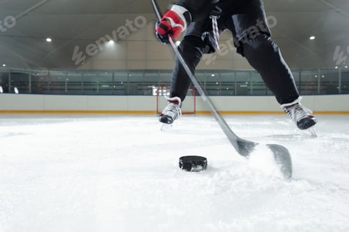 Preview: Male hockey player in sports uniform, gloves and skates moving down rink