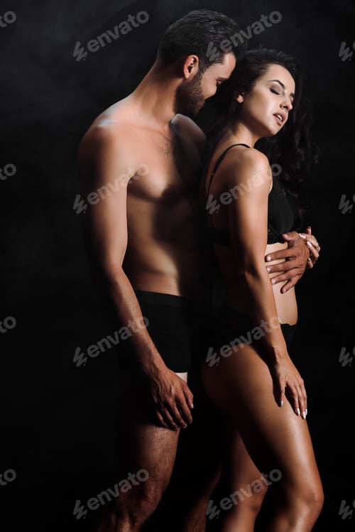 Preview: shirtless man hugging young sexy woman standing on black with smoke