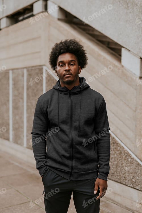 Preview: Man in dark gray zip up hoodie standing by a staircase