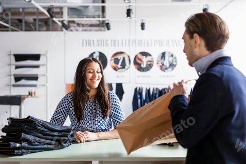 Preview: Young woman buying jeans from factory