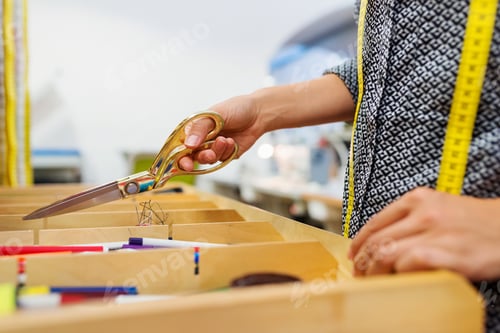 Preview: Unrecognizable tailor woman taking scissors out of a drawer