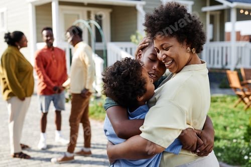 Preview: Black Woman Embracing Two Boys in Sunlight