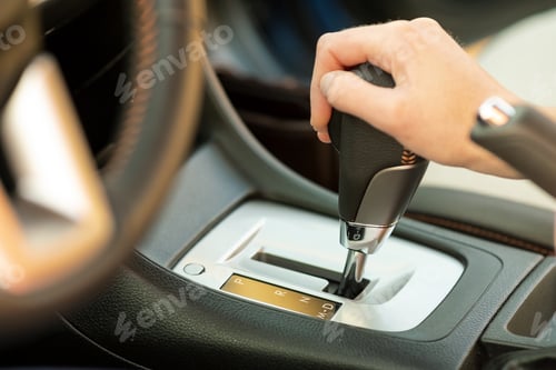 Preview: Close up of woman driver holding her hand on automatic gear shift stick driving as car