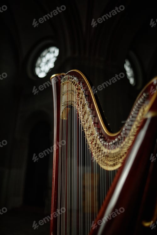 Preview: Strings of Antique Harp with Wooden Curved Frame Standing in Church with Dim Light