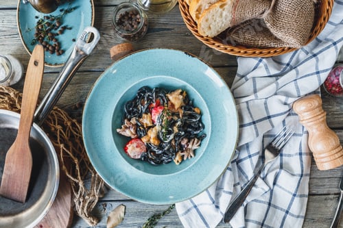 Squid Ink Pasta Dish on Wood Table