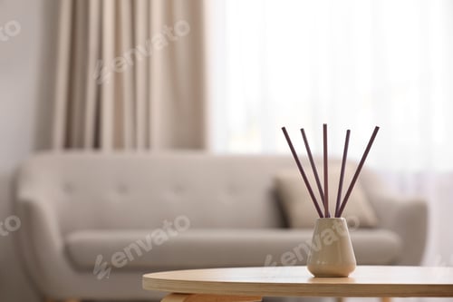 Preview: Reed air freshener with essential oil on table indoors. Space for text