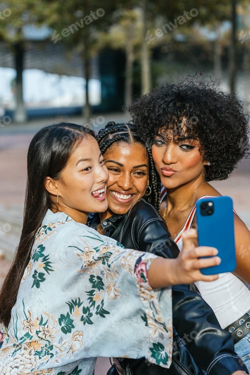 Preview: Happy multi-ethnic women and transgender person taking a selfie together