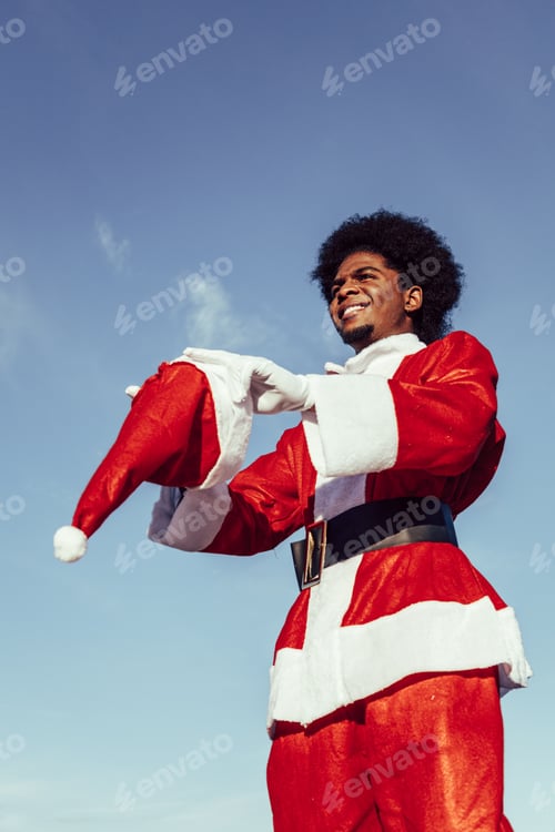 Preview: Young dark skinned santa putting on the christmas hat