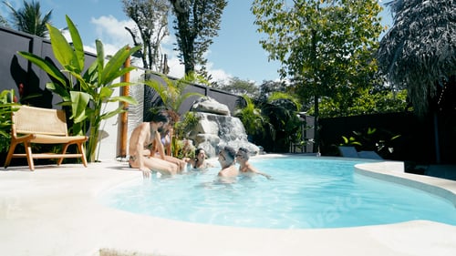 Preview: Friends relaxing together in tropical resort swimming pool