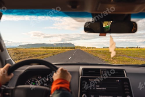 Preview: Road trip with man driving a car on highway through the field in the evening
