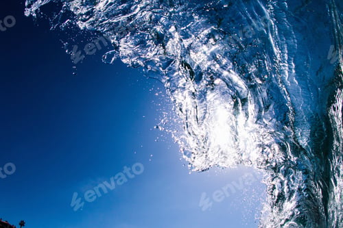 Preview: Low angle view of blue ocean wave rolling and splashing overhead