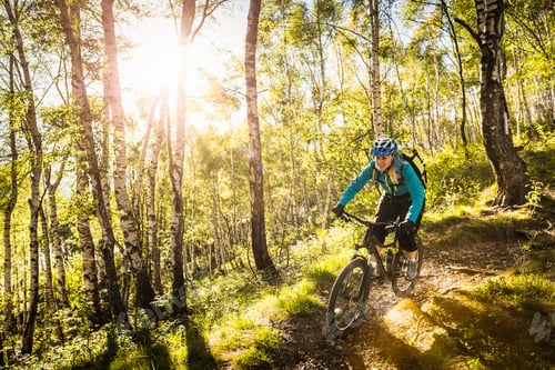Preview: Young woman riding mountain bike through woods, Lake Como, Italy
