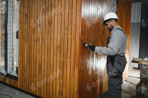 Preview: Skilled worker constructing modular house in workshop