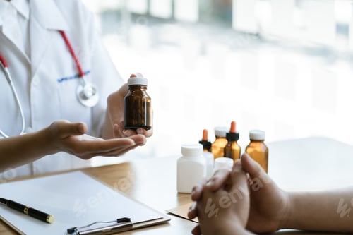 Visualização: Médico confiante segurando um frasco de comprimidos e escrevendo enquanto conversava com o paciente e o avaliava