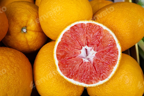 Preview: Orange grapefruit with red pulp at market, citrus background.