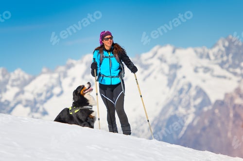 Preview: Alpinist girl on skis and sealskins alone with his dog faithful