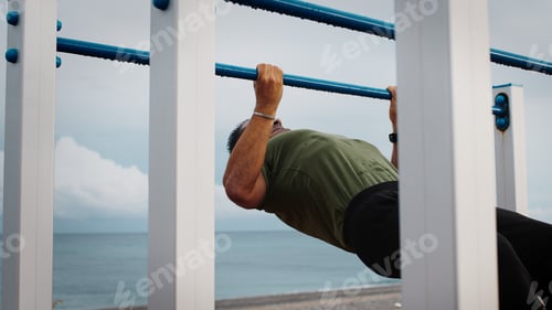 Preview: Male doing australian pull-ups on playground