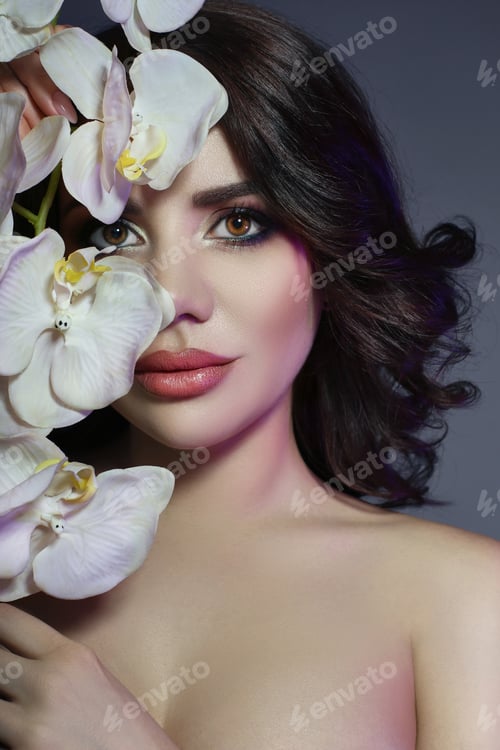 Preview: Beautiful girl with dark hair and big flower near face. White lily flower near woman's face