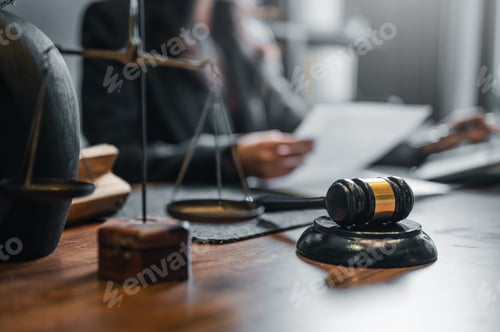 Preview: A judge's gavel sits on a wooden table next to a scale and a book. The scene suggests a courtroom.