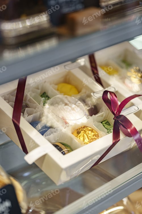 Preview: Colorful dessert gift box with a ribbon displayed in a dessert shop showcase