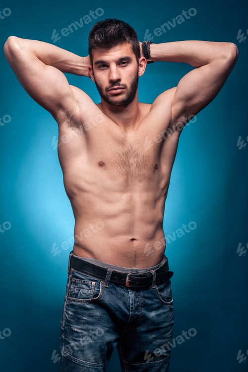 Preview: One Young Adult Man, Shirtless Body, Arms Raised Behind Head, Jeans, Blue Background