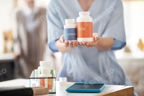 Preview: Close up of medical attendant holding packs of vitamins