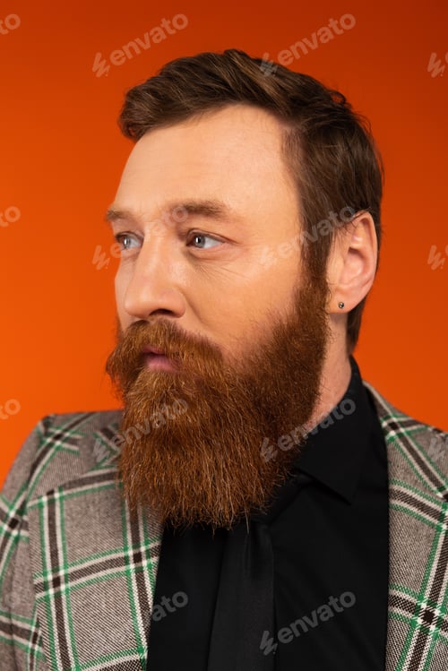 Preview: Portrait of stylish bearded man looking away isolated on red