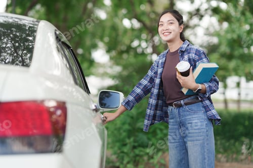 Preview: Young woman opening car door holding coffee book