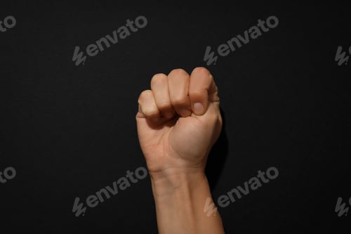 Preview: Clenched human fist on a black background