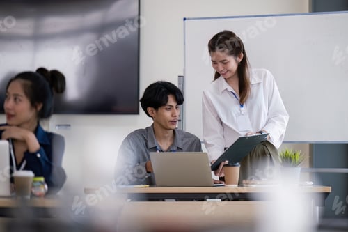 Preview: Business Team Analyzing Data and Discussing Strategy in a Modern Office Setting with Laptops and