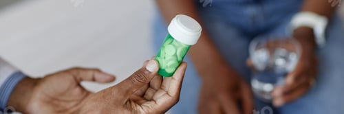 Preview: Black Doctor Holding Prescription Pills Bottle Header Image