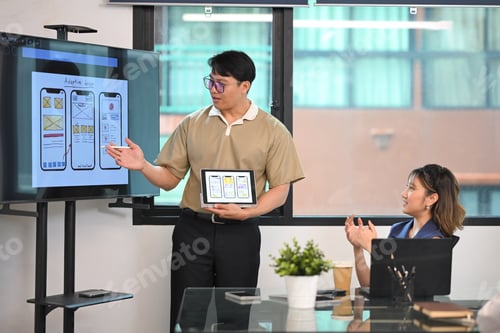 Preview: Diverse group of coworkers discussing UI/UX interface designs in a bright workspace