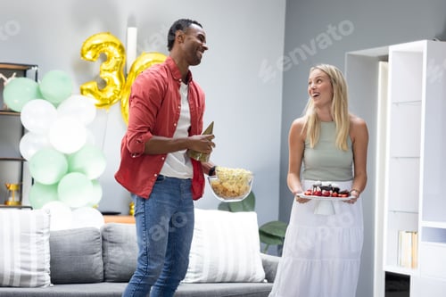 Preview: Friends celebrating birthday at home, sharing snacks and cake with joy