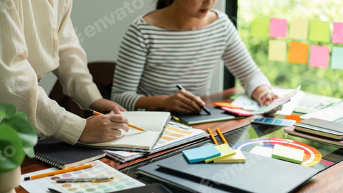 Preview: Two creative graphic designers hold color swatches to discussing and sketching to designing project