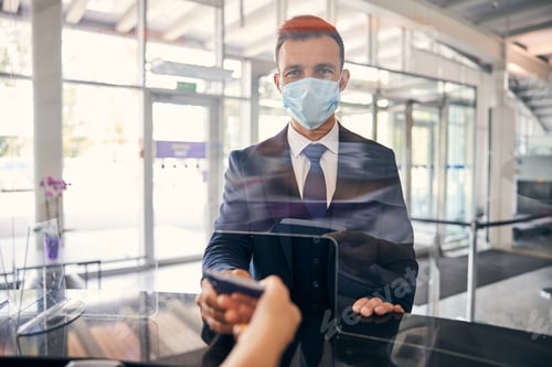 Preview: Diligent traveler wearing a mask at a flight check-in