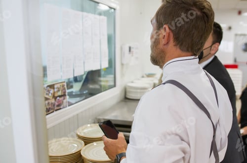 Preview: Back view of the cooks reading the menu for a social event