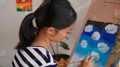 Preview: A girl is painting a picture on a canvas