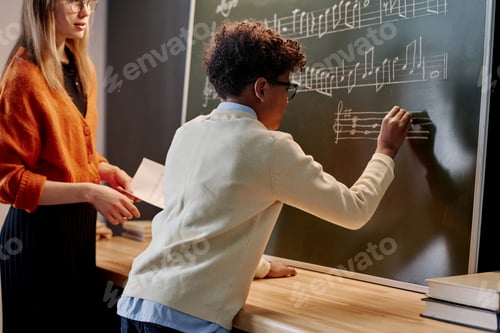 Preview: African American Boy Writing Music Notes On Chalkboard