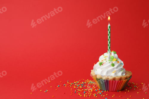 Preview: Birthday cupcake with candle on red background, space for text. Greeting card