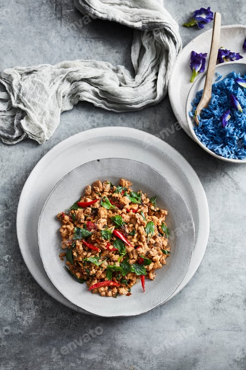 Preview: Spicy minced meat dish garnished with herbs on a plate.